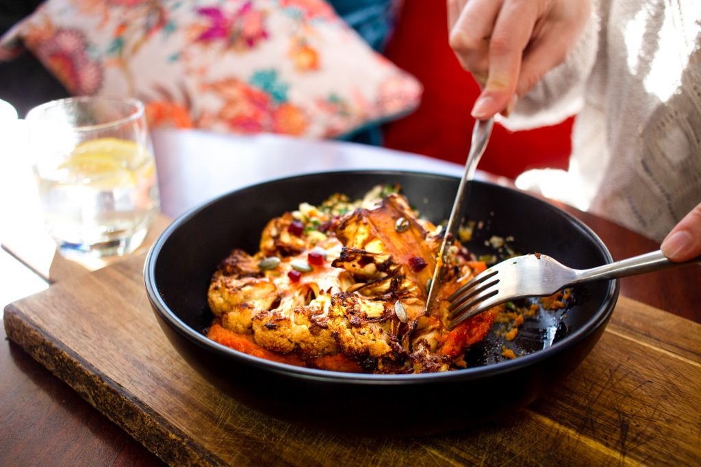 Cauliflower steak on paprika squash hummus